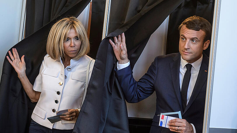 Emmanuel Macron und seine Ehefrau Brigitte kommen am Sonntag aus dem Wahllokal.