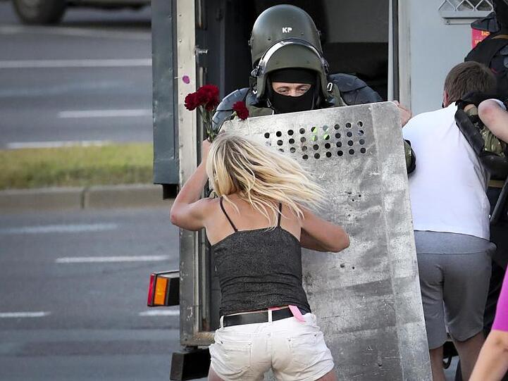 Eine Frau im Clinch mit einem Polizisten, nachdem viele Demonstranten festgenommen worden sind.
