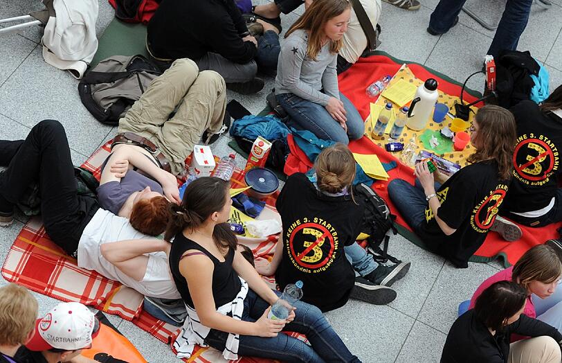 Gegen Fluglärm demonstrierende Demonstranten picknicken am Samstag (24.03.12) am Flughafen Franz-Josef-Strauss in einem Teil der Abflughalle des Terminal 2.