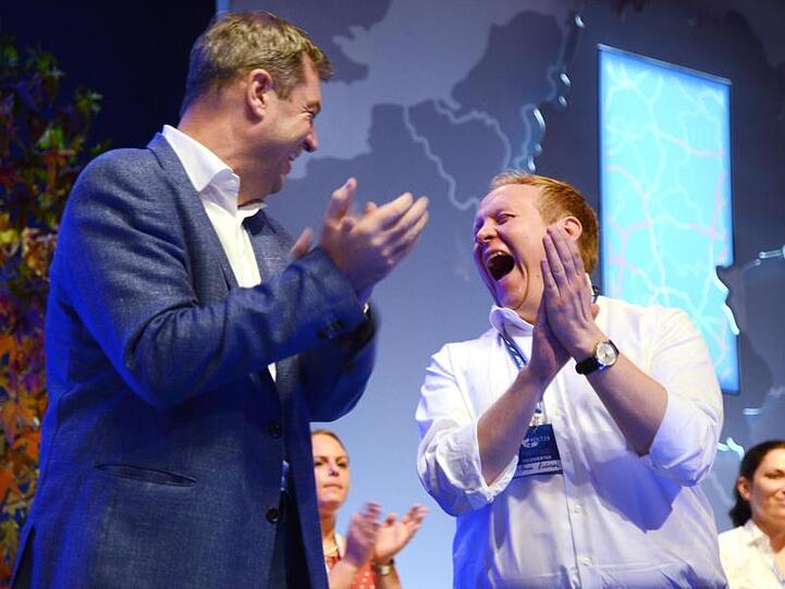 Bayerns Ministerpräsident Markus Söder und JU-Chef Tilman Kuban (r) stehen lachend auf der Bühne in Saarbrücken.