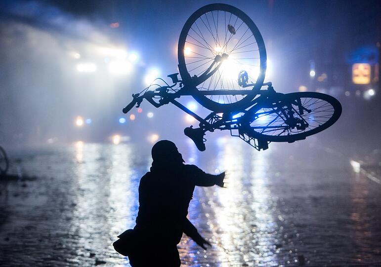 09.07.2017: G20-Gipfel in Hamburg. Ein Randalierer wirft im Schanzenviertel ein Fahrrad in Richtung von Wasserwerfern. In der Hansestadt kommen die Regierungschefs der führenden Industrienationen zum G20-Gipfel zusammen, das Ausmaß der Gewalt bei Randalen und Ausschreitungen schockiert, hunderte Personen werden verletzt.