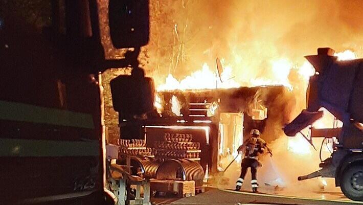 Einsatzkräfte der Feuerwehr München bei einem Brandeinsatz auf einem Betriebsgelände.
