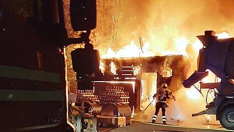 Einsatzkräfte der Feuerwehr München bei einem Brandeinsatz auf einem Betriebsgelände.