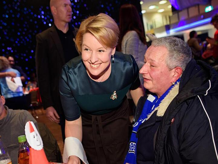 Franziska Giffey (M, SPD), Bundesministerin für Familie, Senioren, Frauen und Jugend, serviert Weihnachtsgans einem Gast.