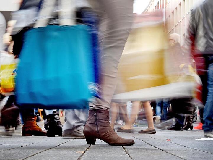 Passanten mit Einkaufstüten. Die deutsche Wirtschaft ist im vergangenen Jahr etwas schwächer gewachsen als zunächst berechnet.