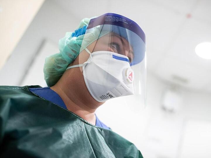 Schutzkleidung und Atemmaske: Die Mitarbeiterin einer Infektionsstation.