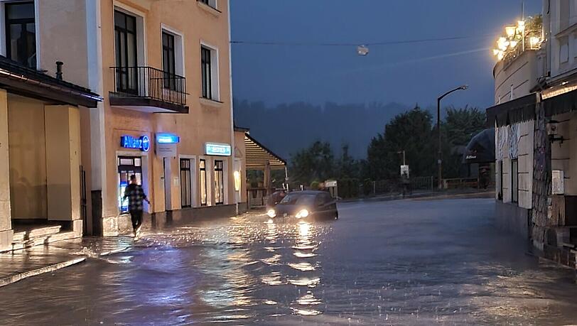 Wasser steht in einer Straße in Berchtesgaden. Der Landkreis Berchtesgadener Land hatte am Samstagabend nach starkem Regen wegen Hochwassers den Katastrophenfall ausgerufen Wasser steht in einer Straße in Berchtesgaden. Der Landkreis Berchtesgadener Land hatte am Samstagabend nach starkem Regen wegen Hochwassers den Katastrophenfall ausgerufen