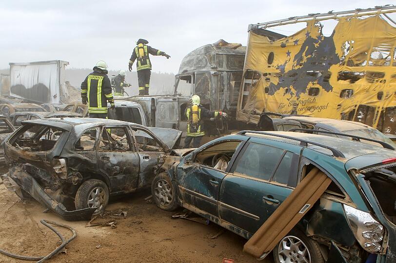 Feuerwehrleute sind am Freitag auf der Autobahn A19 bei Kavelstorf in der Nähe von Rostock bei einer Massenkarambolage im Einsatz. Bei einem Sandsturm fuhren in beiden Fahrtrichtungen Dutzende Fahrzeuge und LKW ineinander und brannten teilweise aus.