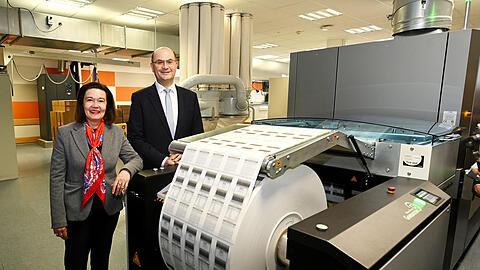 Die Lotto-Chefin Carolin Kerschbaumer und der Finanzminister Albert F&uuml;racker (CSU) vor einer der gro&szlig;en Papierrollen in der Lose-Druckerei. Hier in der Theresienh&ouml;he 11 laufen j&auml;hrlich 55 bis 60 Millionen Aufrei&szlig;lose durch die Maschinen.