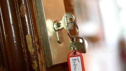Ein Schlüssel mit der Aufschrift "Ferienwohnung" hängt an einer Wohnungstür. Foto: Britta Pedersen/Archivbild