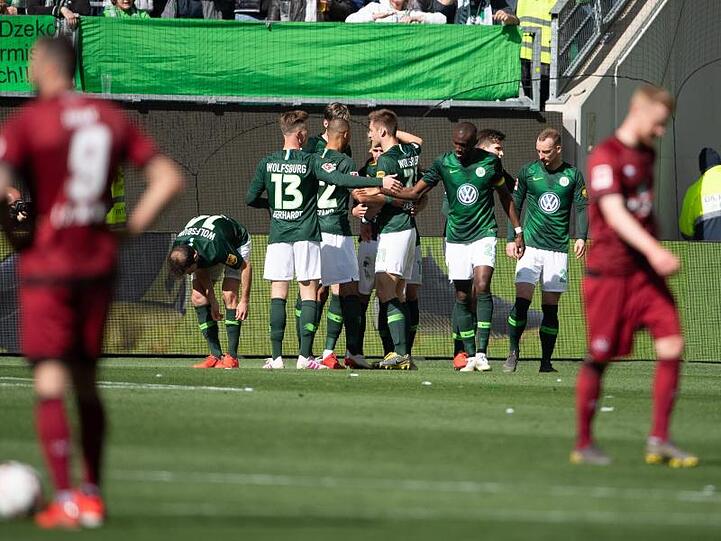 Wolfsburgs Spieler jubeln nach dem 1:0, die Nürnberger lassen im Vordergrund die Köpfe hängen.
