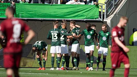 Wolfsburgs Spieler jubeln nach dem 1:0, die Nürnberger lassen im Vordergrund die Köpfe hängen.