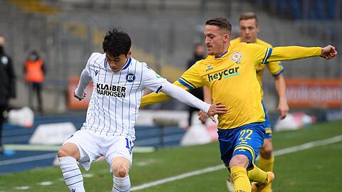 KSC-Profi Kyoung-Rok Choi (l) schirmt den Ball gegen den Braunschweiger Manuel Schwenk ab.