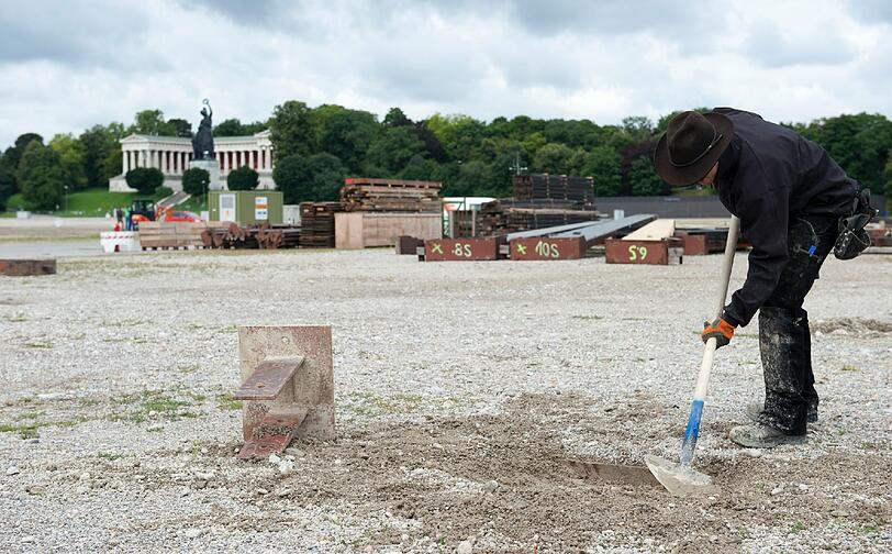 Ein Arbeiter schaufelt auf der Theresienwiese in Muenchen zu Beginn der Aufbauarbeiten fuer das Oktoberfest vor der Bavaria im Boden