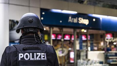 Ein Polizist steht vor der Tankstelle, an der ein Angestellter von einem Mann erschossen worden ist.