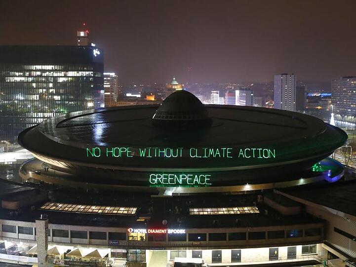 Greenpeace beleuchtet den Mehrzweck-Arenenkomplex "Spodek" mit den Worten "No hope without climate action - Greenpeace".
