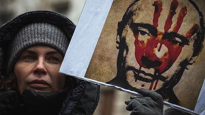 Blutige Hand: Eine Demonstrantin in Belgrad hält ein Anti-Putin-Plakat in die Höhe.