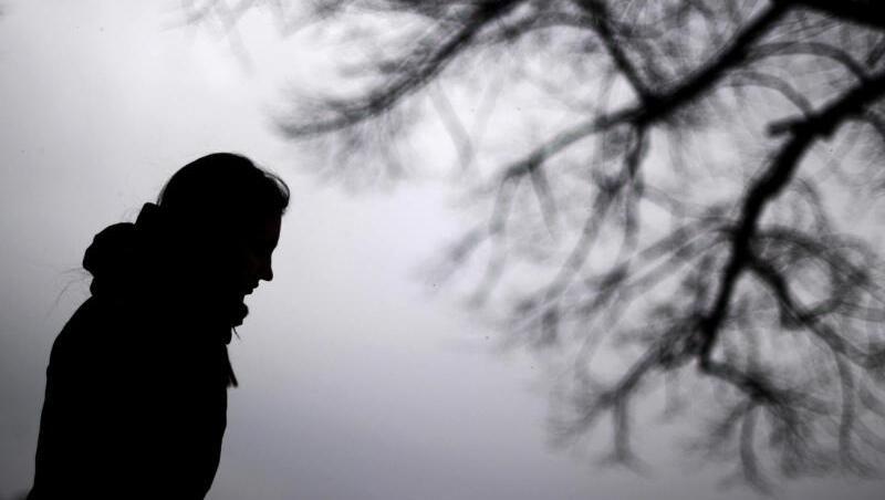 Dunke Silhouette eines Menschen ist neben einem kahlen Baum zu sehen. Foto: Julian Stratenschulte/Archivbild Dunke Silhouette eines Menschen ist neben einem kahlen Baum zu sehen. Foto: Julian Stratenschulte/Archivbild