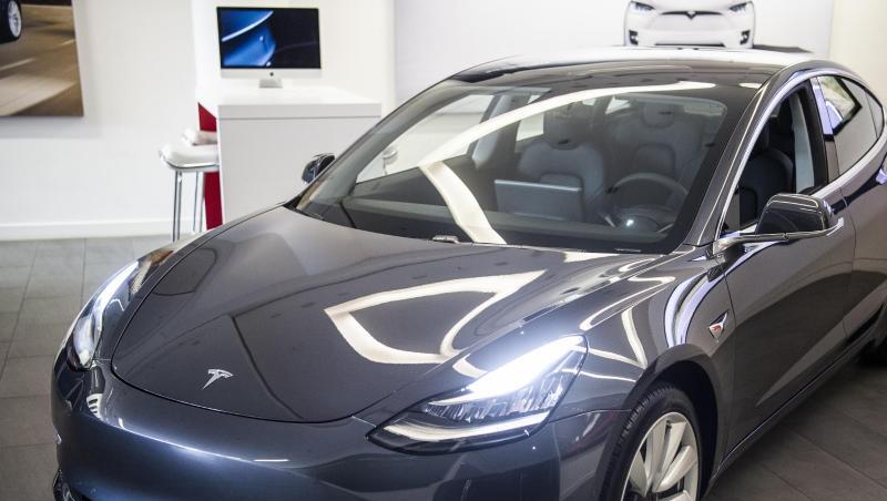 Das Elektroauto Model 3 von Tesla steht in einem Ausstellungsraum.