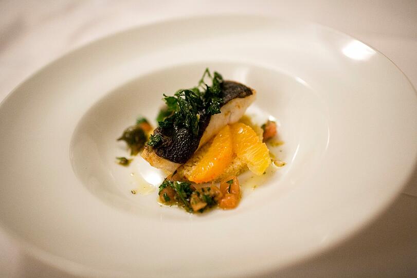 3. GANG: Gebratenes Filet vom Steinbutt &ndash; Sauce Vierge &ndash; Orangen-Zitronen-Couscous. &bdquo;Sauce Vierge&ldquo; wird in Frankreich oft zu Fisch serviert; sie besteht klassisch aus Olivenöl, Zitronensaft, gehackten Tomaten und Basilikum. Mit dem Orangen-Zitronen-Couscous ein frischer Genuss; den leichten Fischgang komplettiert der Riesling &bdquo;Alte Reben&ldquo; vom Weingut Schuth im Rheingau, Jahrgang 2012, mit seinem feinen Zusammenspiel von Pfirsichsüße, Säure und Mineralik.