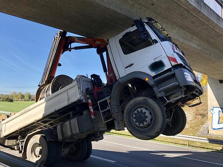 Ein LKW steht nach hinten gekippt an der Unfallstelle. Foto: Hermann Spanner/Feuerwehr Bichl/dpa