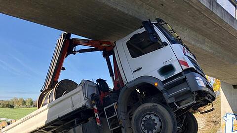Ein LKW steht nach hinten gekippt an der Unfallstelle. Foto: Hermann Spanner/Feuerwehr Bichl/dpa