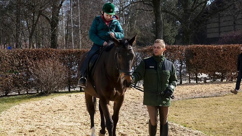 Maxi sitzt zum ersten Mal im Sattel eines Polizeipferds. Reitlehrer Stefan Eder führt Emilio am Zügel. Maxi sitzt zum ersten Mal im Sattel eines Polizeipferds. Reitlehrer Stefan Eder führt Emilio am Zügel.