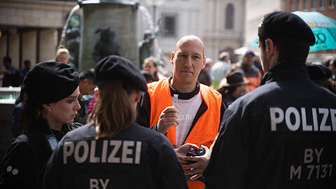 Der Aktivist der "Letzten Generation" Wolfgang Metzeler-Kick protestierte am 20.5.2023 in München gegen das gegen ihn verhängte Sekundenklebertransportverbot, indem er Sekundenkleber mitführte und ein großes Fass mit einem UHU Aufkleber mitführte.