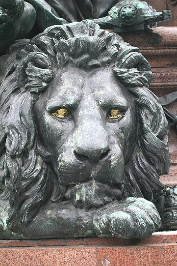 Im November 2010 hatten Unbekannte dem Löwen die Augen angemalt, der Figur daneben die Nägle lackiert. Die Entfernung löste auch die Patina, die bildet sich seitdem neu.