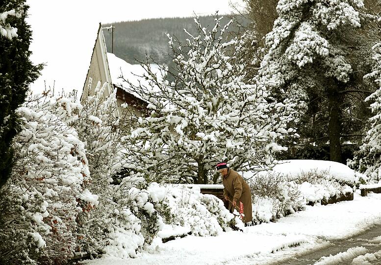 Auchterarder, Perthshire, in Schottland: Eine Frau schaufelt Schnee vor ihrem Haus - kurios: Diese Aufnahme stammt vom 3. April!