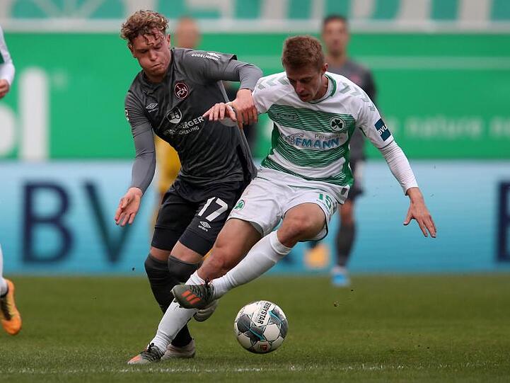 Der Nürnberger Robin Hack (l.) und Fürths Sebastian Ernst kämpfen um den Ball. Foto: Daniel Karmann/dpa