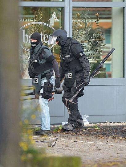 Mit erhobenen Händen kommt ein Mann auf die SEK-Beamten zu, im Hintergrund lauern Heckenschützen der Polizei. Die Beamten nehmen den Mann fest, es ist aber nicht der Täter, der sich in einem Imbiss in Freiburg veschanzt hat.