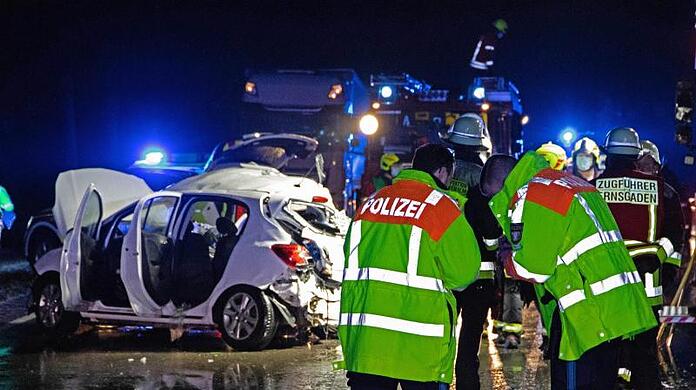 Polizisten und Feuerwehrleute stehen an der Unfallstelle auf der B16.