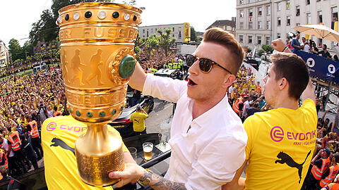 Marco Reus hält den Pokal neben Julian Weigl auf dem Mannschafts-LKW in Dortmund