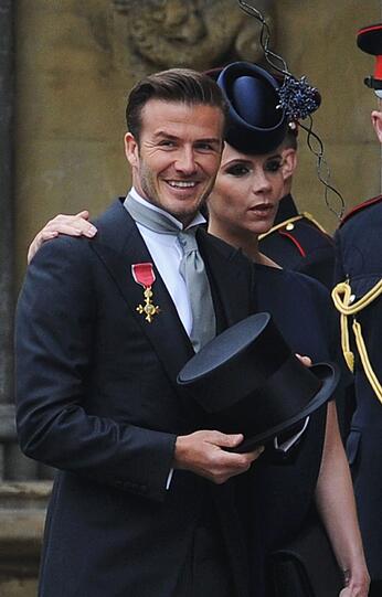 Fußballstar David Beckham mit Zylinder und Frau Victoria.