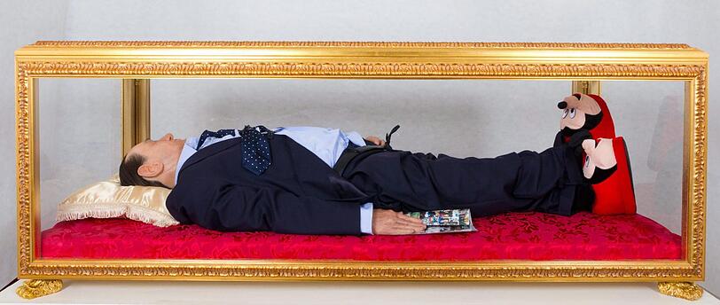 Wie ein Heiliger - oder wie Mao und Lenin? - Eine Wachsfigur von Silvio Berlusconi aufgebahrt in einem Glassarg.