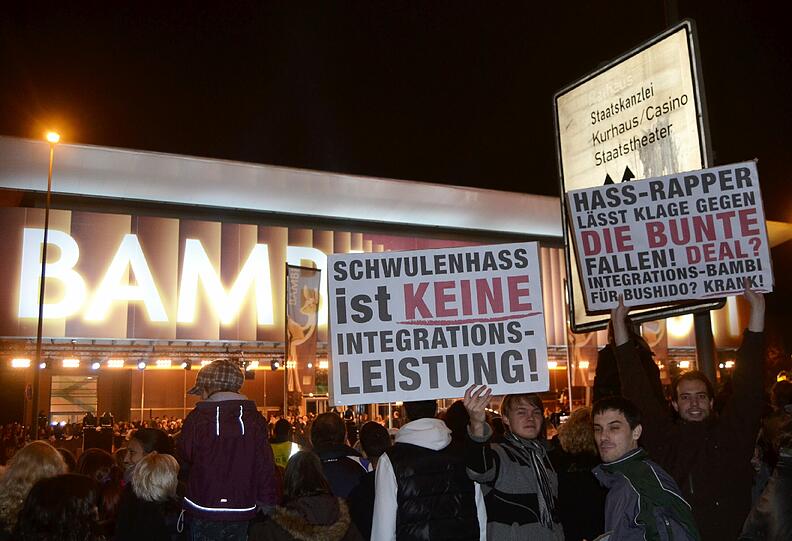 Mit großen Plakaten protestieren Demonstranten vor den Rhein-Main-Hallen in Wiesbaden gegen die Verleihung des Integrations-Bambis an Bushido.