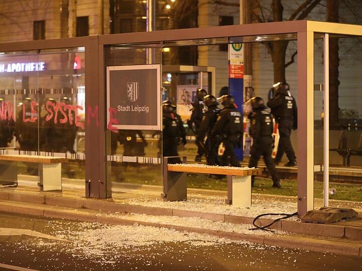 Reste einer eingeschlagenen Scheibe liegen neben einer Straßenbahnhaltestelle.