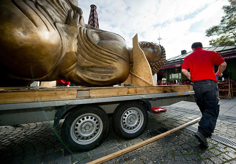 Ende einer Kunstaktion: Der liegende Buddha vom Viktualienmarkt wird abgebaut und auf einem Tieflader festgezurrt.