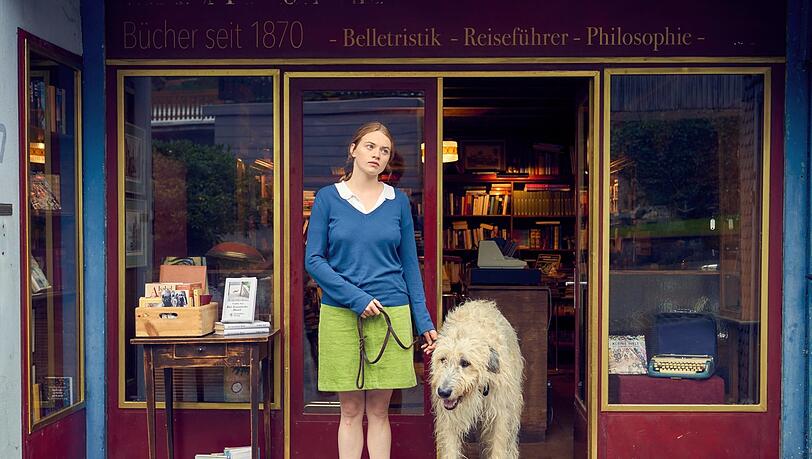 Luise (Luna Wedler) und Hund Alaska vor der Buchhandlung