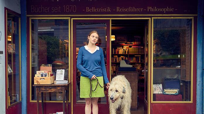 Luise (Luna Wedler) und Hund Alaska vor der Buchhandlung