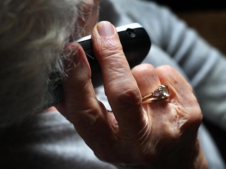 Eine ältere Frau telefoniert mit einem schnurlosen Festnetztelefon. Foto: Karl-Josef Hildenbrand/dpa/Illustration
