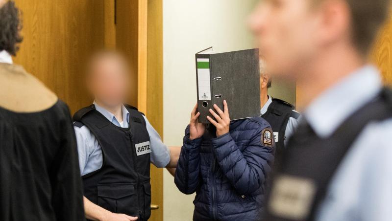 Einer der Angeklagten kommt in den Gerichtssaal. Einer der Angeklagten kommt in den Gerichtssaal.