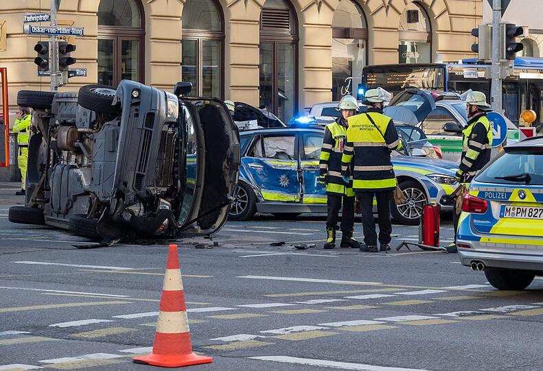 Einsatzkräfte der Polizei und Feuerwehr stehen an der Unfallstelle.