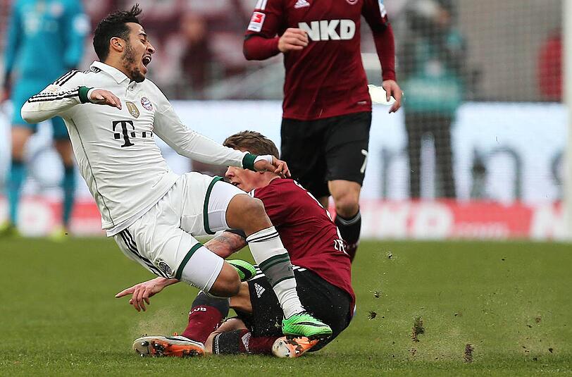 Da staubt&rsquo;s! Thiago (l.) vom FC Bayern München wird von Mike Frantz (1. FC Nürnberg) von den Beinen geholt. Rechts sieht man den Sand, der bei jedem Zweikampf aufgewirbelt wurde.