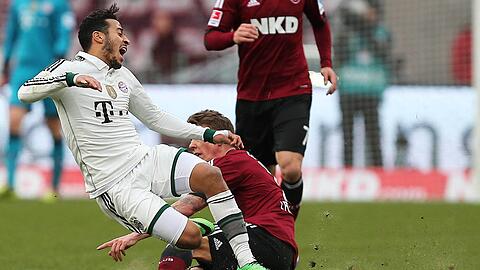 Da staubt&rsquo;s! Thiago (l.) vom FC Bayern München wird von Mike Frantz (1. FC Nürnberg) von den Beinen geholt. Rechts sieht man den Sand, der bei jedem Zweikampf aufgewirbelt wurde.