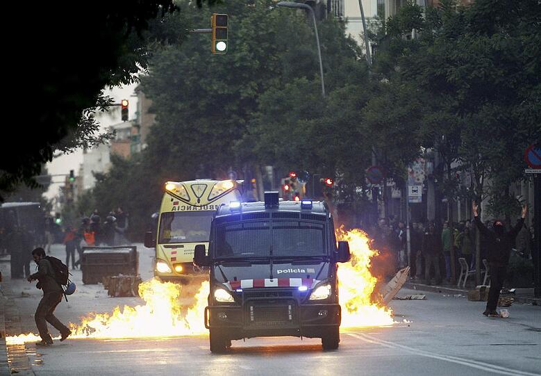 Ein Fahrzeug in Barcelona brennt lichterloh. Dort toben Proteste gegen die Evakuierung eines von Hausbesetzern bewohnten Hauses.