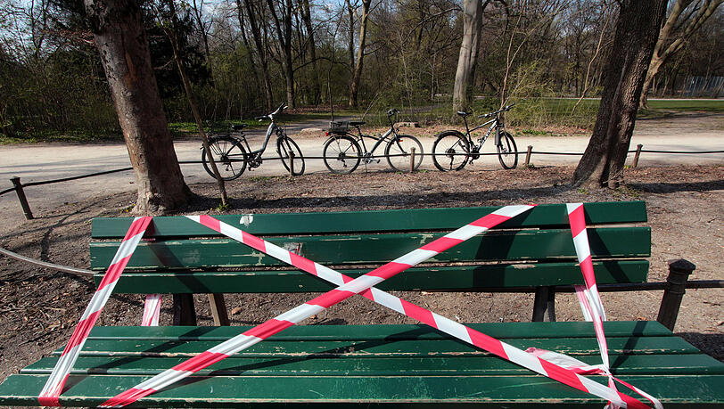 Im Park Englischer Garten sind zur Eindämmung des Coronavirus Parkbänke mit einem Absperrband gesperrt worden, um die zahlreichen Besucher und Sonnenhungrigen vom längeren Verweilen abzuhalten, München, Bayern, Deutschland. Im Park Englischer Garten sind zur Eindämmung des Coronavirus Parkbänke mit einem Absperrband gesperrt worden, um die zahlreichen Besucher und Sonnenhungrigen vom längeren Verweilen abzuhalten, München, Bayern, Deutschland.