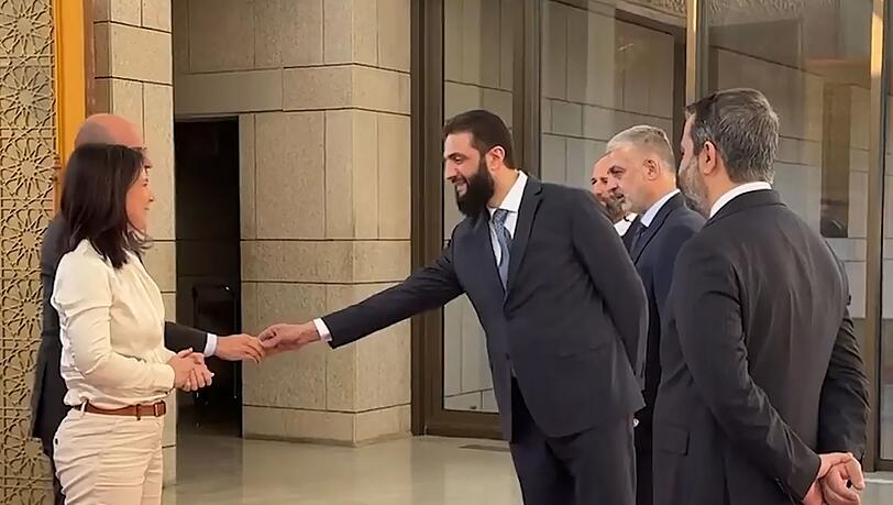 Ausgestreckte Hand nur für den männlichen Minister: Rebellenchef al-Scharaa.