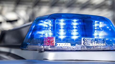 Das Blaulicht an einem Polizeiwagen leuchtet.